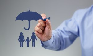 Businessman hand drawing an umbrella above a family concept for protection, security, finance and insurance